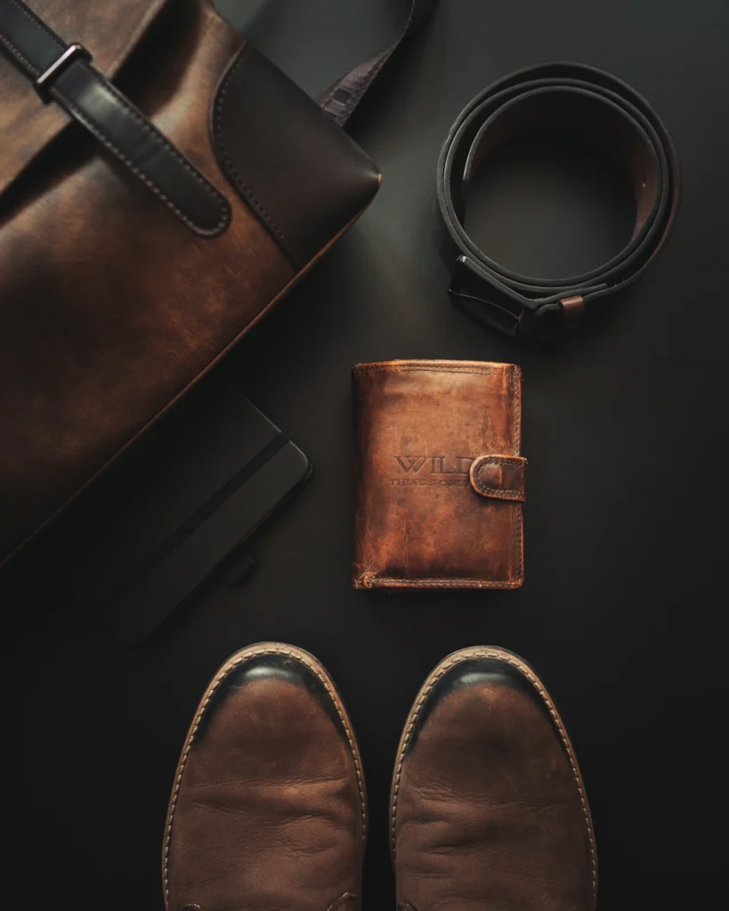 Cinto, carteira e sapatos de couro masculinos sobre fundo escuro