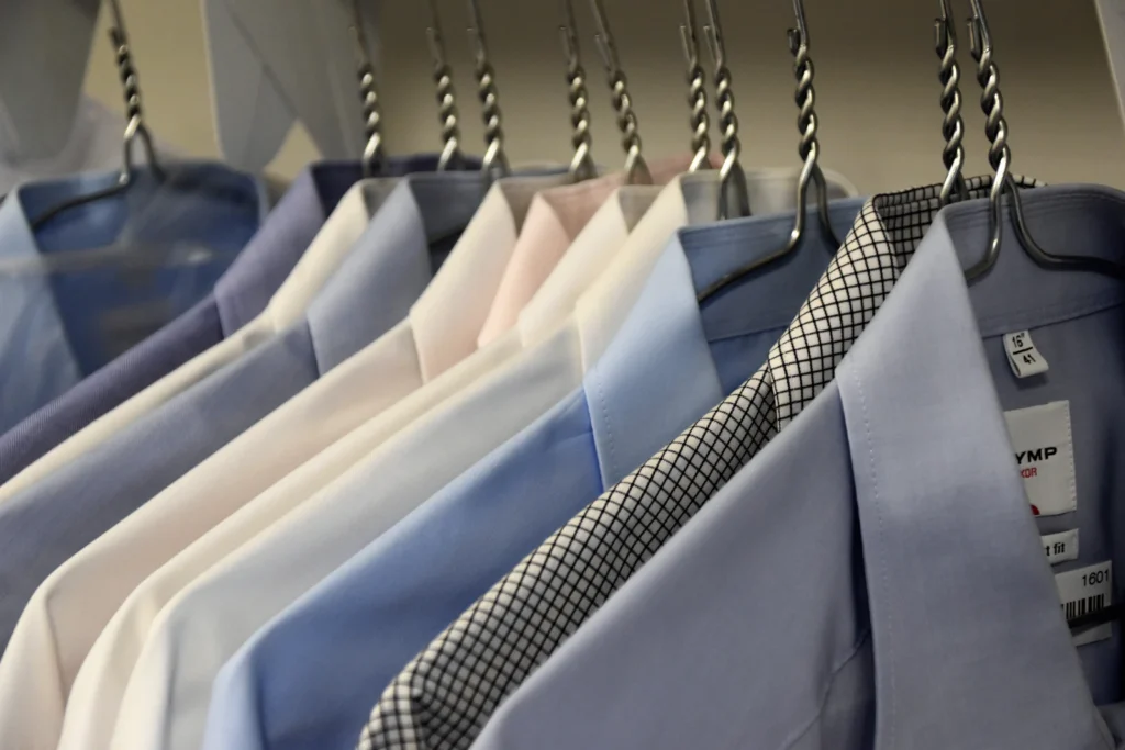 Camisas e paletós masculinos de várias cores pendurados em cabides